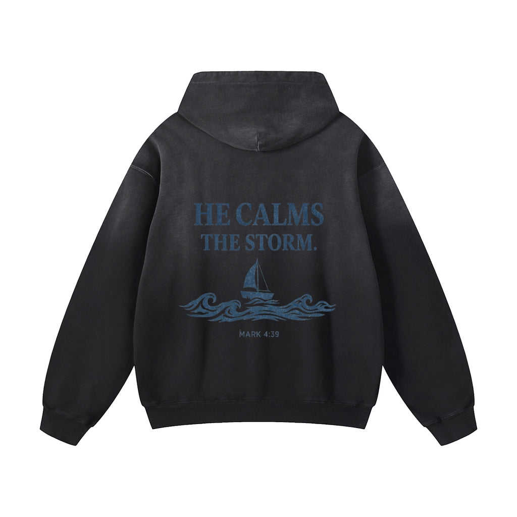 Foundation MARK 4:39 Standard Oversized Hoodie in charcoal grey with a blue graphic of a sailboat on waves and text "HE CALMS THE STORM."