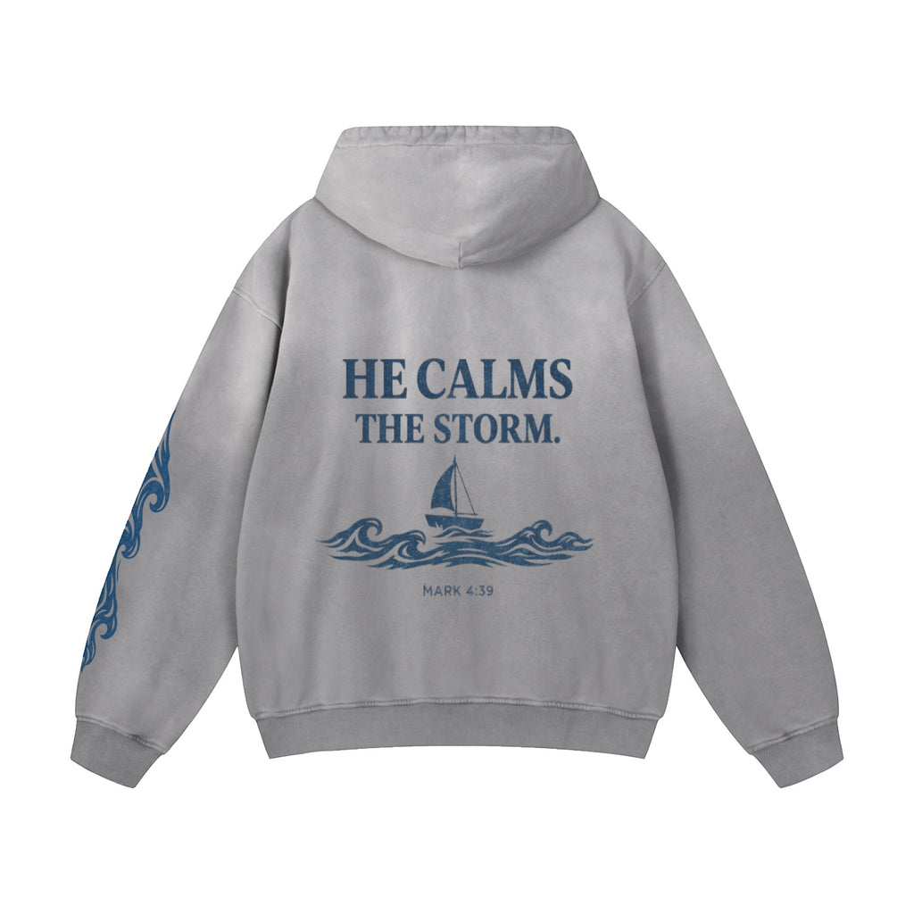 Foundation Deluxe Oversized Hoodie in grey with "HE CALMS THE STORM" graphic and sailboat on waves. Sleeve graphics.