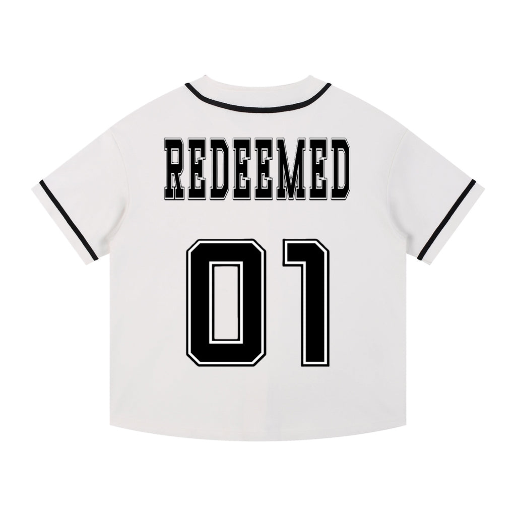 Foundation white baseball jersey with black trim, featuring "REDEEMED" across the back and "01" numbering.